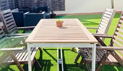 a wooden table with two chairs and a potted plant on it at El Ático de la Angelita by RentCadiz in El Puerto de Santa María