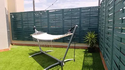 a hammock on a balcony with a green fence at El Ático de la Angelita by RentCadiz in El Puerto de Santa María