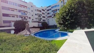 a swimming pool in front of a building at El Ático de la Angelita by RentCadiz in El Puerto de Santa María