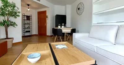 a living room with a white couch and a table at El Ático de la Angelita by RentCadiz in El Puerto de Santa María