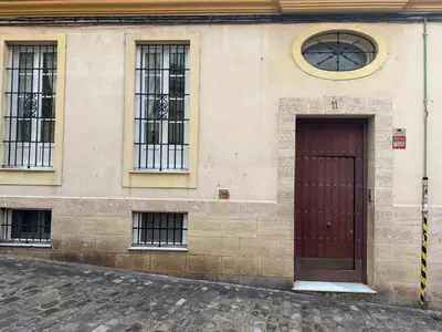 a building with a red door and three windows at La Casita Gaditana Centro in Cádiz