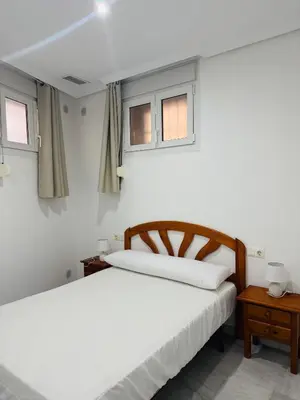 a bedroom with two beds and two windows at La Casita Gaditana Centro in Cádiz