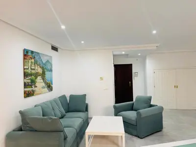 a living room with two blue couches and a table at La Casita Gaditana Centro in Cádiz