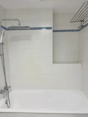 a white bathroom with a shower with a mirror at La Casita Gaditana Centro in Cádiz