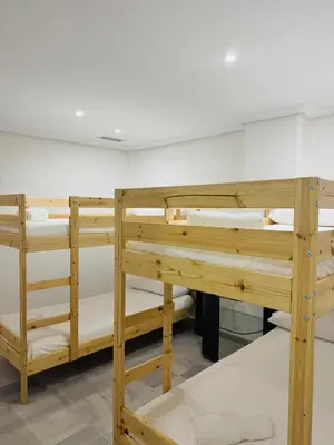 a row of wooden bunk beds in a room at La Casita Gaditana Centro in Cádiz