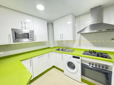 a kitchen with white cabinets and a washing machine at La Casita Gaditana in Cádiz