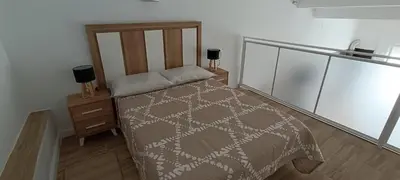 a bedroom with a bed and a night stand at Apartamento VILLASUR in Alcalá de los Gazules
