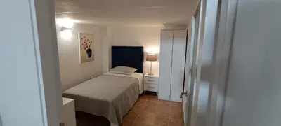 a small bedroom with a bed and a lamp at Apartamento VILLASUR in Alcalá de los Gazules