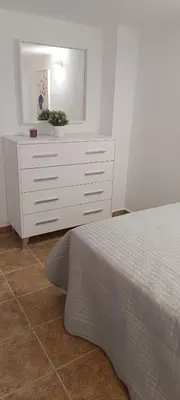 a bedroom with a white dresser and a bed at Apartamento VILLASUR in Alcalá de los Gazules