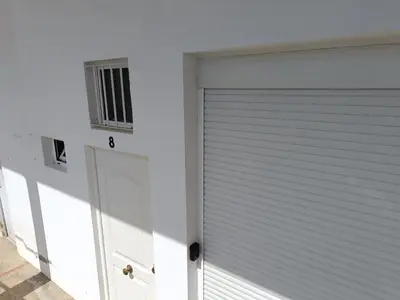 a white garage door with a window on it at Apartamento VILLASUR in Alcalá de los Gazules
