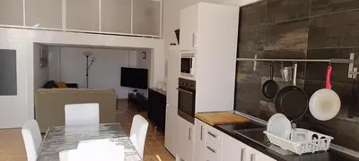 a kitchen with a sink and a table with a counter at Apartamento VILLASUR in Alcalá de los Gazules