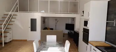 a living room with a table and a kitchen at Apartamento VILLASUR in Alcalá de los Gazules