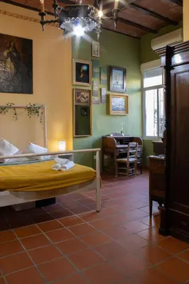 a bedroom with a bed and a dining room with a table at La Posada de Zepeda in Jerez de la Frontera
