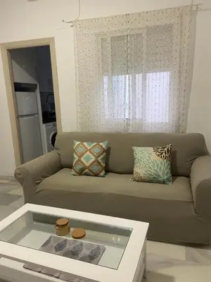 a living room with a couch with a glass table at Casa Alzar2 in Jerez de la Frontera