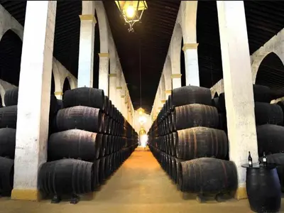 a row of wine barrels in a wine cellar at Casa Alzar2 in Jerez de la Frontera