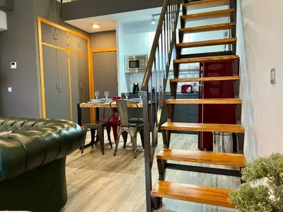 a spiral staircase leading to a dining room with a table at Paradise Vista in Poblado de Sancti Petri