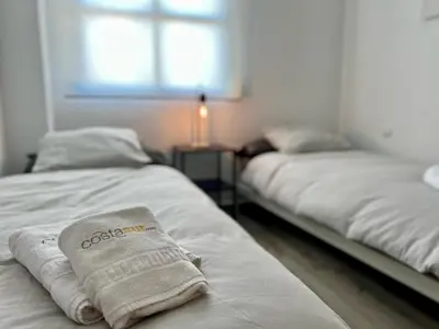 two beds with towels on them in a room at Paradise Vista in Poblado de Sancti Petri