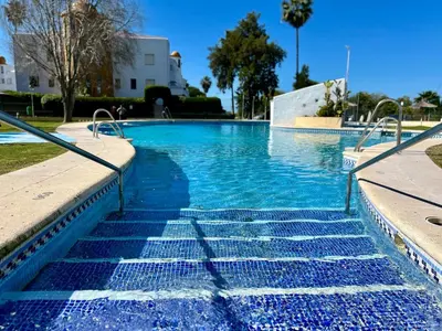 a swimming pool with blue water and stairs at Paradise Vista in Poblado de Sancti Petri