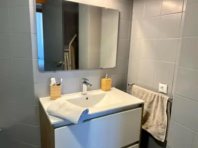 a bathroom with a sink and a mirror and towels at Paradise Vista in Poblado de Sancti Petri