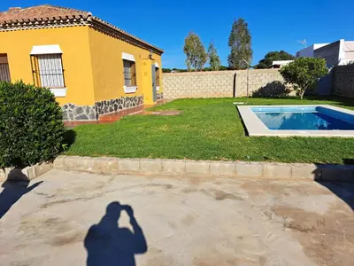 a shadow of a man taking a picture of a house at Villa Encanto Chiclana in Novo Sancti Petri