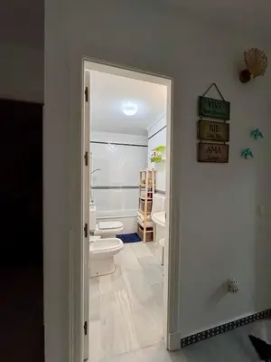 a bathroom with a toilet and a door leading to a bathroom with a sink at Precioso Adosado El Cormorán Novo Sancti Petri in Novo Sancti Petri