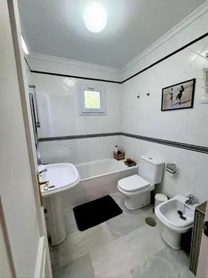 a white bathroom with a sink and a toilet at Precioso Adosado El Cormorán Novo Sancti Petri in Novo Sancti Petri