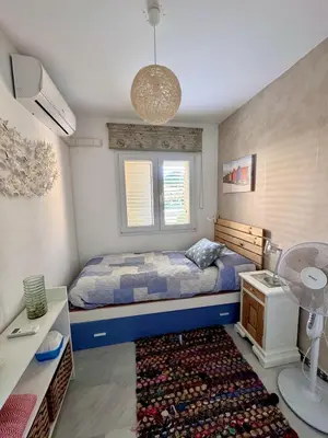 a small bedroom with a bed and a rug at Precioso Adosado El Cormorán Novo Sancti Petri in Novo Sancti Petri