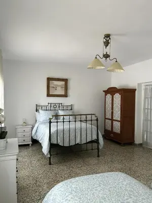 a bedroom with a bed and a dresser and a lamp at Casa rural Pinar de la Plata in Arcos de la Frontera