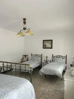 a bedroom with two beds and a chandelier at Casa rural Pinar de la Plata in Arcos de la Frontera