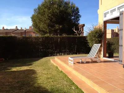 a white chair sitting on a patio in a yard at Cerca del Mar in Novo Sancti Petri
