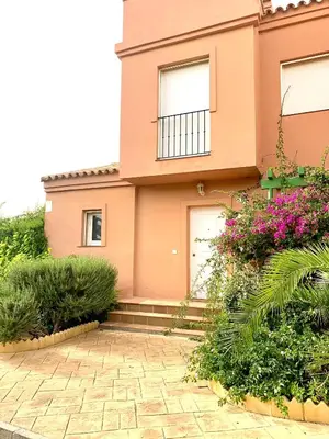a pink house with flowers in front of it at Cerca del Mar in Novo Sancti Petri