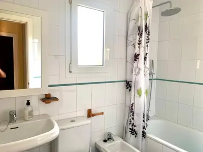 a white bathroom with a sink and a shower curtain at Cerca del Mar in Novo Sancti Petri
