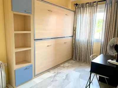 a room with a closet with a desk and a window at Cerca del Mar in Novo Sancti Petri