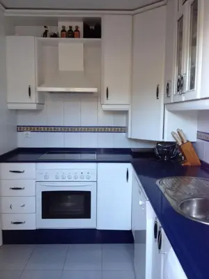 a kitchen with white cabinets and a white oven at Cerca del Mar in Novo Sancti Petri