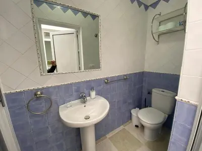 a bathroom with a sink and a toilet and a mirror at El Descanso de Chipiona in Chipiona