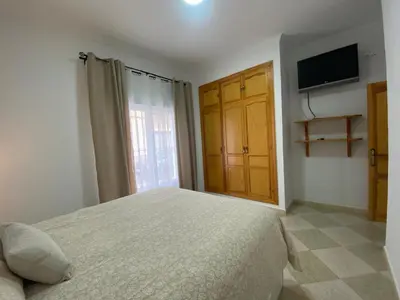 a bedroom with a bed and a television and a window at El Descanso de Chipiona in Chipiona