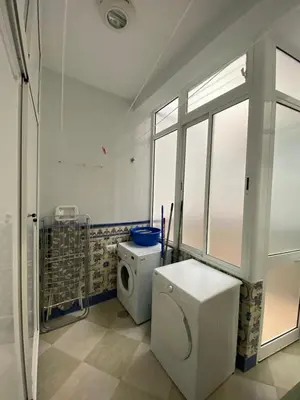 a white bathroom with a toilet and a window at El Descanso de Chipiona in Chipiona