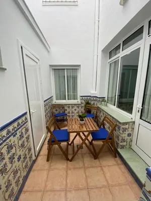 a patio with a table and chairs on a balcony at El Descanso de Chipiona in Chipiona