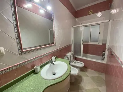 a bathroom with a sink and a toilet and a mirror at El Descanso de Chipiona in Chipiona