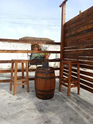 a table and two stools and a barrel with a table and chairs at El Girasol yellowstone in Chiclana de la Frontera