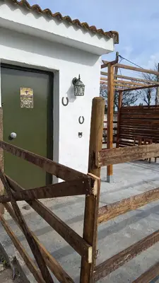 a building with a green door and a fence at El Girasol yellowstone in Chiclana de la Frontera
