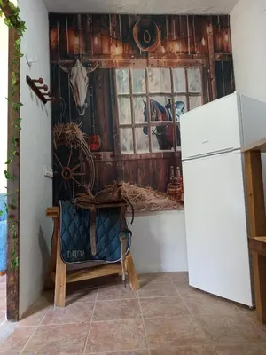 a kitchen with a refrigerator and a wall with a window at El Girasol yellowstone in Chiclana de la Frontera