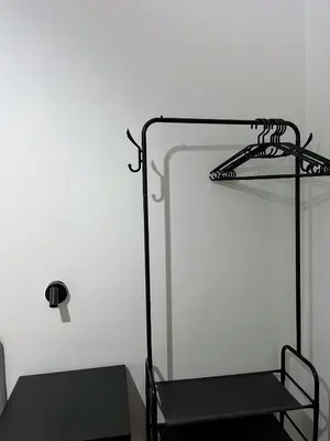 a black chair in a room with a white wall at El Piso in Sanlúcar de Barrameda