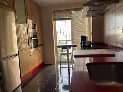 a kitchen with a counter and a table in it at El Piso in Sanlúcar de Barrameda