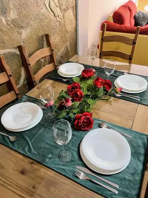 a table with white plates and red roses on it at El Piso in Sanlúcar de Barrameda