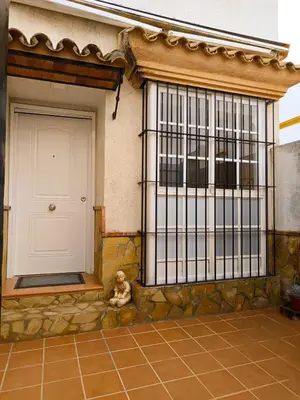 a teddy bear sitting in front of a door at La Playita de Arcos in Arcos de la Frontera