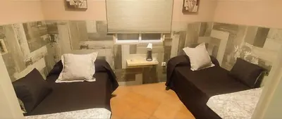 a bedroom with two beds and a table with a lamp at La Playita de Arcos in Arcos de la Frontera