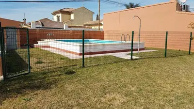 a fence in front of a swimming pool at El Cotín Rural House in Novo Sancti Petri