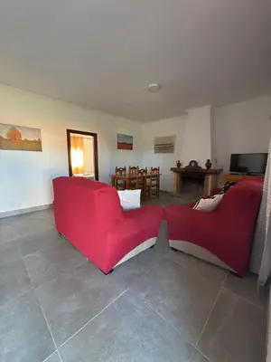 a living room with two red couches and a table at El Cotín Rural House in Novo Sancti Petri