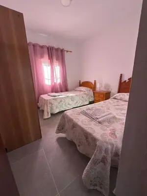 a bedroom with two beds and a window at El Cotín Rural House in Novo Sancti Petri